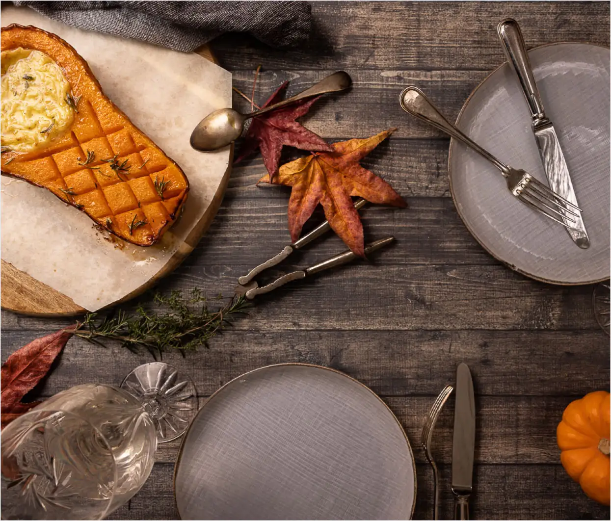 A picture of a dinner table with leaves and pumpkin