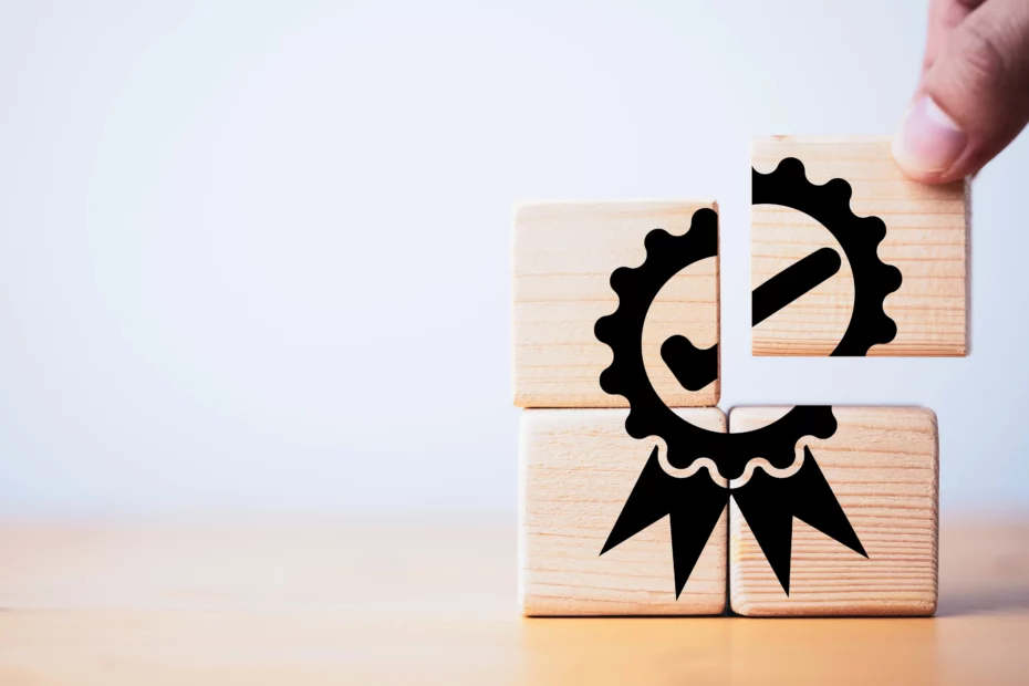 A person stacking wooden cubes making a certification symbol.