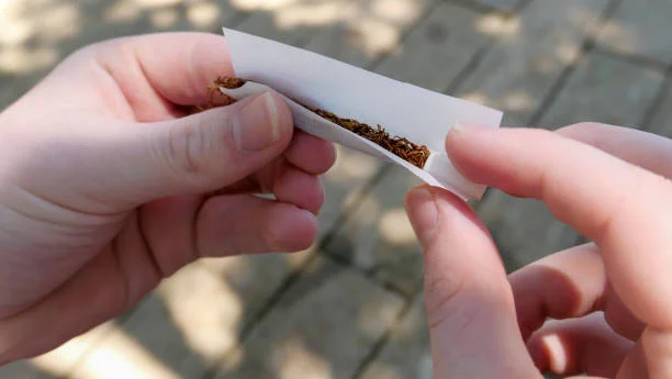 A person rolling a cigarette